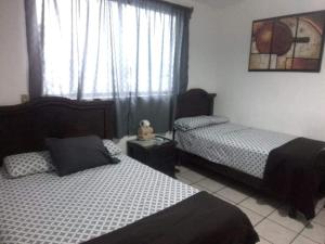 a bedroom with two beds and a window at Hotel Raíz de Sierra in Matlapa