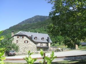 ein großes Steinhaus vor einem Berg in der Unterkunft Hotel Casa Estampa in Escuñau