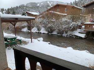 a winter view of a river with snow on the ground at Telemark #4 Townhouse On The River in Red River