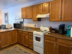 a kitchen with wooden cabinets and a white stove top oven at Telemark #4 Townhouse On The River in Red River