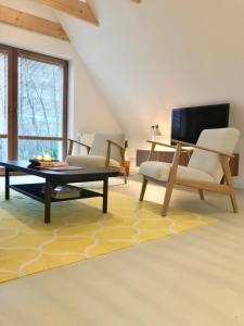 a living room with two chairs and a coffee table at Moorblick! Große Dachwohnung mit Kamin und Sauna in Leck
