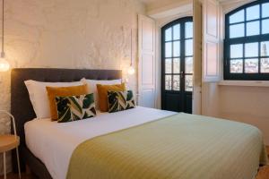 a bedroom with a large bed and two windows at AgapeStay Porto in Porto