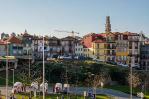 una ciudad con edificios y coches en una calle en AgapeStay Porto, en Oporto