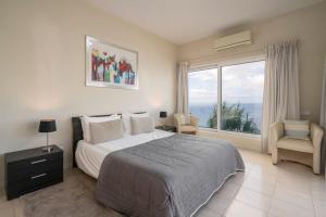 カニコにあるOurMadeira - Villa Aquarela, panoramic seaviewsのベッドルーム(大型ベッド1台、大きな窓付)
