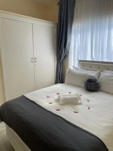 a white bed with red flowers on it at @Jackie’s Avondale 2 bed flat at Harrow court in Harare