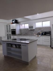 a large white kitchen with a stove top oven at Apartamento a la orilla de la playa en Pampatar, Isla de Margarita in Pampatar