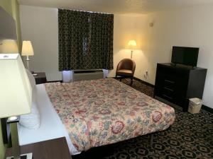 a hotel room with a bed and a television at King's Inn in Torrington