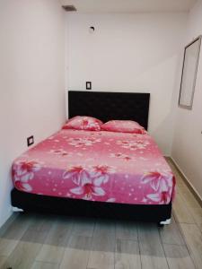 una camera con letto rosa con lenzuola e cuscini rosa di Departamento para 4 personas en ezeiza a Ezeiza