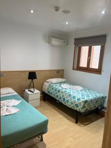 um quarto com duas camas e uma janela em Hostal Restaurante em Pamplona