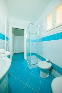 a blue bathroom with two sinks and a shower at Residence San Francesco in Tirrenia