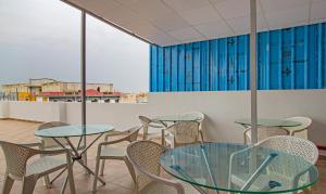 Habitación con mesas, sillas y cortinas azules. en Treebo Trend Abhi Suites, Guntur, en Guntūr