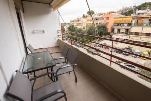 uma varanda com cadeiras e vista para a cidade em Vicky's Luxury Apartment em Kanoni