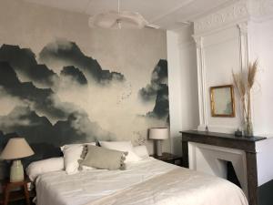 una camera con un letto e un dipinto di nuvole di Chambres d'hôtes La Tour d'Aspiran ad Aspiran