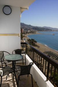 balkon ze stołami i krzesłami oraz widokiem na plażę w obiekcie beachfront apartment w Maladze