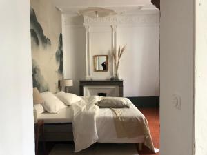 um quarto com uma cama com um espelho e uma lareira em Chambres d'hôtes La Tour d'Aspiran em Aspiran