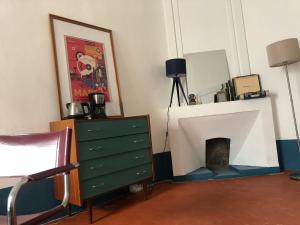 a living room with a fireplace and a green dresser at Chambres d'hôtes La Tour d'Aspiran in Aspiran