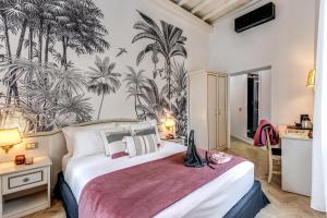 a bedroom with a large bed with palm trees on the wall at Baboon Room in Rome