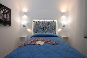 una camera con letto blu e un libro sopra di Strit strit centro storico ad Amalfi