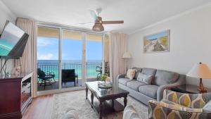 a living room with a couch and a view of the ocean at Emerald Beach #1331 by Nautical Properties Vacation Rentals in Panama City Beach