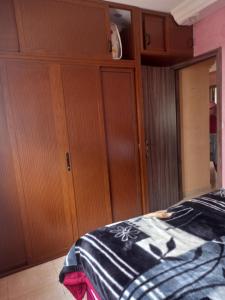 a bedroom with wooden cabinets and a bed at اقامة الحديقة الضحى عمارة 54 العيايدة سلت in Sale