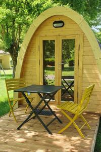 a picnic table and two chairs in front of a gazebo at Cabane 2/3 pers au Camping les Patis in Nazelles