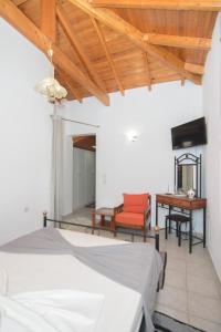 een slaapkamer met een bed, een tafel en een bureau bij Samian Thalia Apartment in Pagóndas