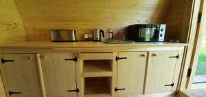 drewniany blat z dwoma mikrofalami na górze w obiekcie Cabane 2/3 pers au Camping les Patis w mieście Nazelles