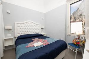 a bedroom with a bed with a book and a window at Vittoria House Centro Storico in Amalfi