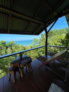 a deck with a table and chairs and the ocean at Sunset Lodge in Drake