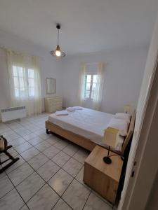 - une chambre blanche avec un lit dans l'établissement Olga's Place, à Spetses