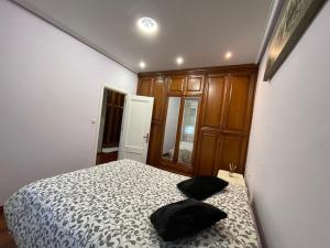 um quarto com uma cama com duas almofadas pretas em Apartamento con encanto en la cuidad de oro termal em Ourense