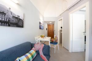 uma sala de estar com um sofá azul e uma mesa em Vittoria House Centro Storico em Amalfi