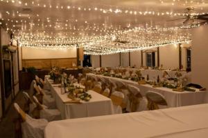un salón de banquetes con mesas blancas, sillas y luces en Ranchette Ponderosa - The Timpanogos #1 at Wind Walker Homestead, en Spring City
