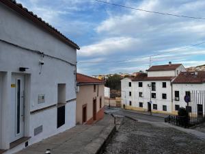 an empty street in a town with white buildings at Consolación17 in Cáceres