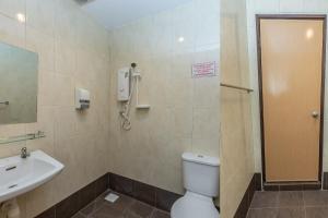 een badkamer met een toilet, een wastafel en een douche bij Hash House Hotel in Melaka