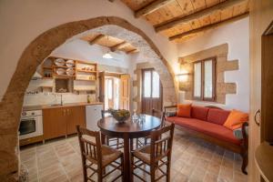 Villa Veneciana with Heated Pool في Kástellos: مطبخ وغرفة معيشة مع طاولة وأريكة