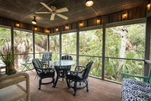 a screened in porch with a table and chairs at 359 Tarpon Blvd in Fripp Island