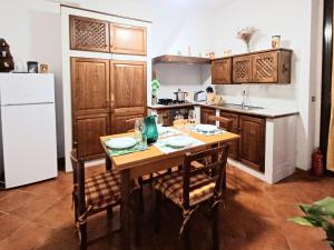 a kitchen with a wooden table and a white refrigerator at Casa Chianti in Mercatale Val Di Pesa