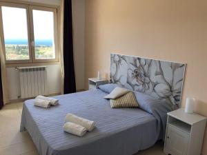 a bedroom with a large bed with a head board at Villa MiraScopello in Castellammare del Golfo