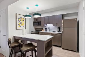a kitchen with a white counter and a refrigerator at WaterWalk Atlanta Perimeter Center in Atlanta