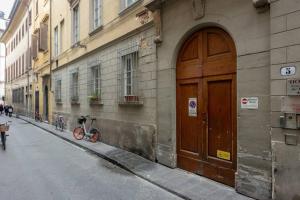 een fiets geparkeerd naast een gebouw met een houten deur bij Borgo Pinti's Duplex Apartment in Florence
