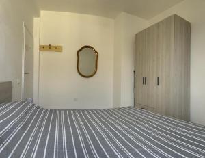 1 dormitorio con cama y espejo en la pared en Appartamento Mare Fuori, en Vada