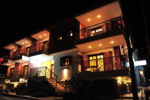 a large building with balconies and stairs at night at Pansion Evi in Ammouliani