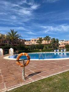 a swimming pool with a orange lifesaver in front of it at Casares del Sol Apartment in Casares