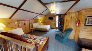 um quarto com uma cama e uma cadeira num quarto em The Outback On The Creek With High Speed Wifi em Red River