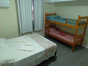 Łóżko lub łóżka piętrowe w pokoju w obiekcie Pousada cafe com margarida 150 metros do mar rua do calçadao da central