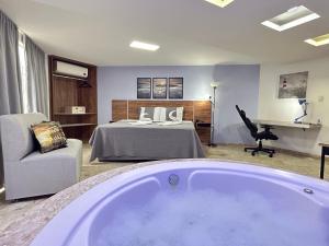um quarto com uma cama e uma banheira em Belavista Hotel em Itaberaba