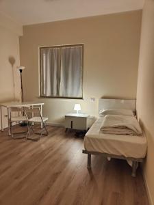 Schlafzimmer mit einem Bett, einem Schreibtisch und einem Fenster in der Unterkunft Casa dello Studente in Vittorio Veneto