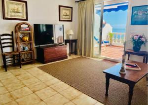 a living room with a television and a table at Casa Yaya Nerja in Nerja
