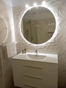 uma casa de banho com um lavatório branco e um espelho. em Apartamento Green Park Relax em San Miguel de Abona
